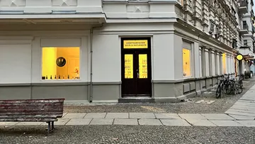 Wine shop with big windows and yellow lights.