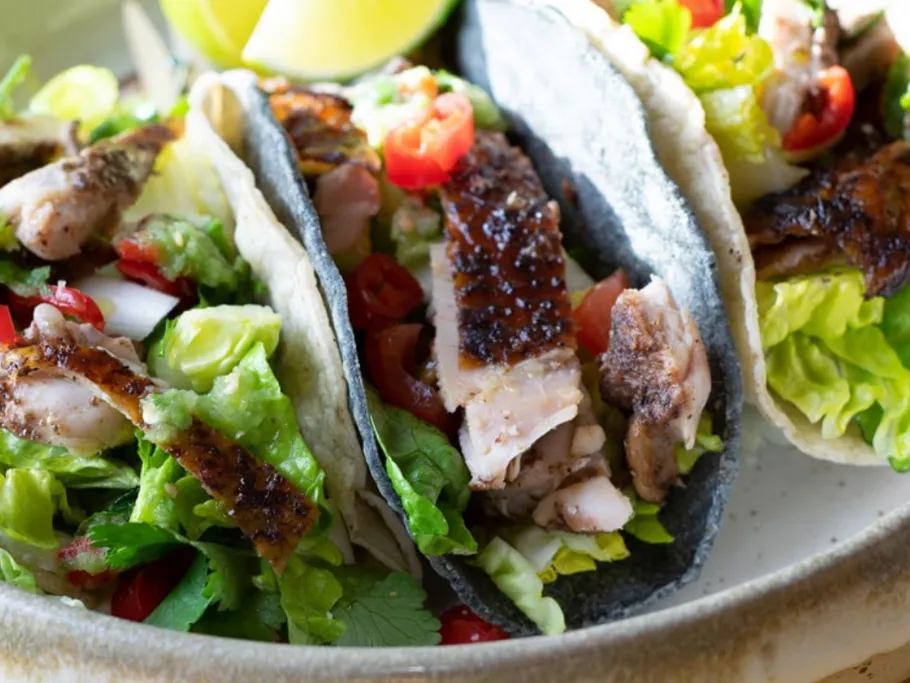 Drei Tacos mit gegrilltem Hühnchen und frischem Gemüse.