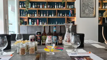 Tische mit Getränken, Gläsern und Snacks in einer Bar.