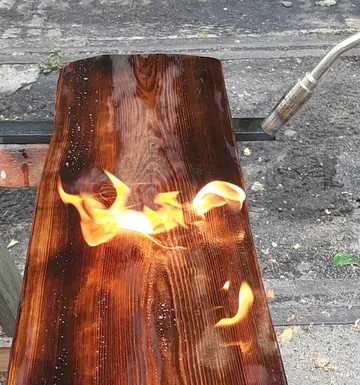 Brennholz wird mit einer Lötlampe bearbeitet.
