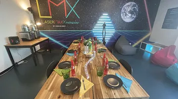 Ein langer Tisch mit buntem Geschirr in einem Spielraum.