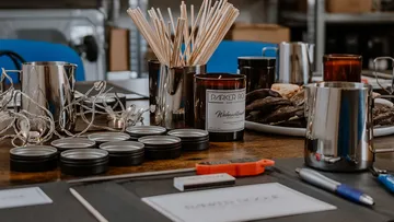 Candle utensils lie on a wooden table for an event.