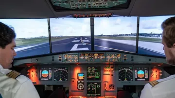 Pilots in airplane cockpit simulator.