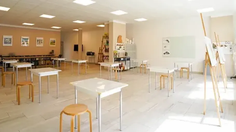 Empty tables are set in a bright, modern room.