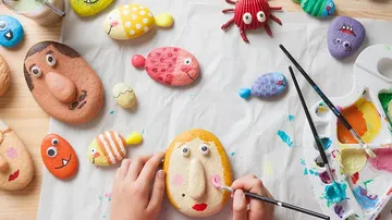 Stones are painted with faces and animals.