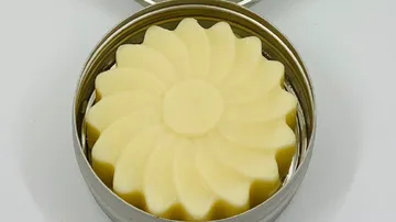 Flower-shaped soap, is in a round tin.