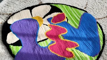 Colourful rug topper with abstract shapes and floral motifs.