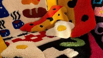 Colourful rugs with food motifs in a room.