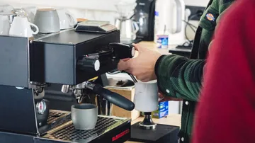Kaffeekapselmaschine brüht Kaffee in einer modernen Café-Umgebung.