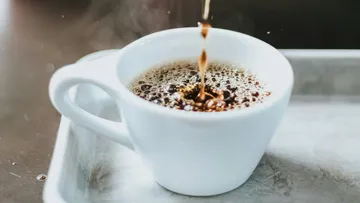 Mug fills with steaming coffee on a surface