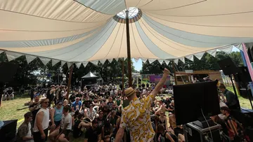 People listen to a man in a tent.