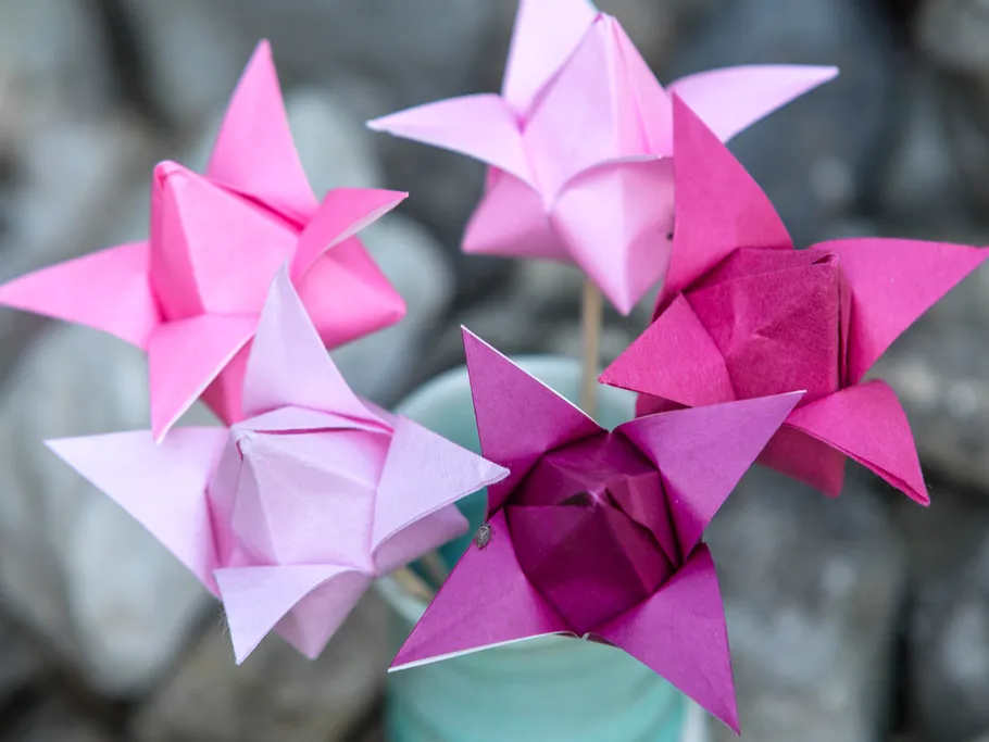 Paper stars stand on stones in a green vase.