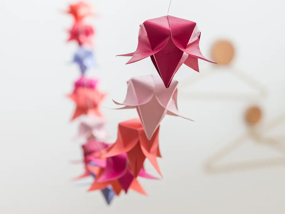 Fold flowers hang elegantly in a bright room.