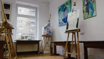 Canvases stand on easels in an artist's studio.