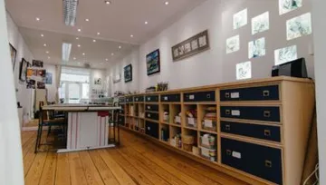 Holztisch in einem hellen Raum mit Regalen und Bildern.