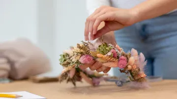 Flower wreath is put together; creative crafts at the table