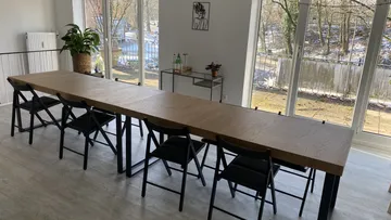 There is a long table with chairs in a quiet room.