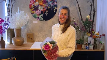 Frau hält einen Strauß im Blumenladen in der Hand.