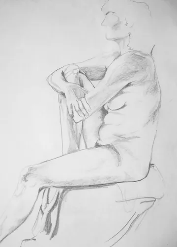 Naked person sits with arms and legs crossed.