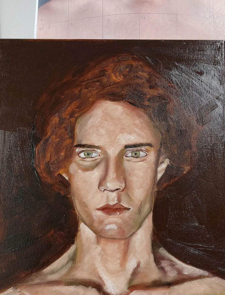 Portrait of a man with short, curly hair and a green look.