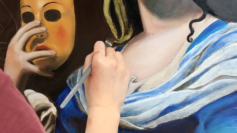 A hand paints on a painting with a mask.