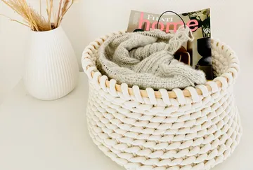 Basket contains a blanket and a magazine, decorative