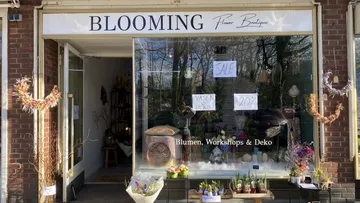 Flower shop with decorative objects and offers in the window.
