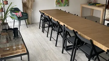 Long row of tables with chairs in a bright room.