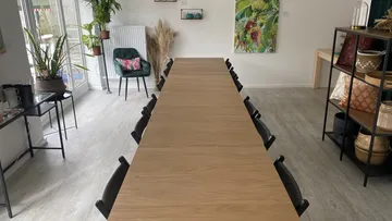 A long table is empty in a bright room.