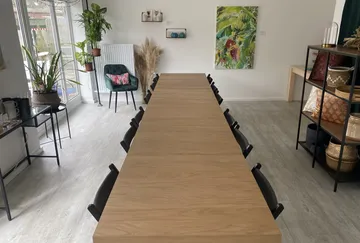 Long wooden table in a bright meeting room.