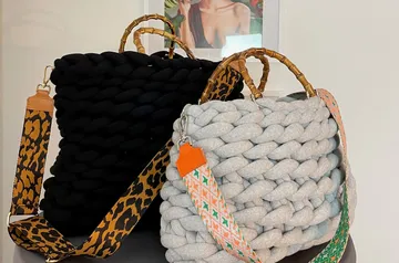 Zwei stylische Taschen stehen auf einem Tisch im Raum.