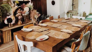 Holztisch gedeckt mit Tellern in einem dekorativen Raum.