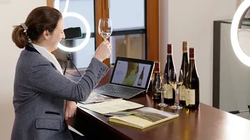 A woman raises a wine glass at a modern wine tasting.