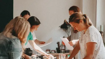 A group of women work together at a table.