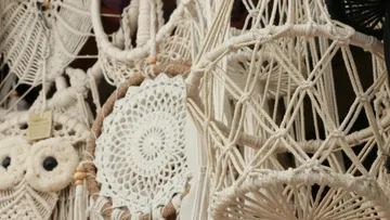 Macrame works hang, artfully woven, in a sales room.
