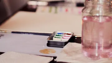 Water pot and color palette on a table, expected use
