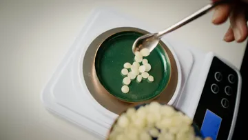 Balls are placed on a scale with a spoon.
