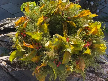 A wreath of colorful leaves and berries lies quietly.