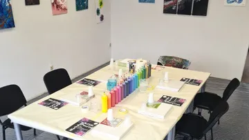 A table with painting supplies in a creative space.