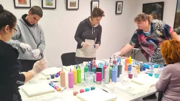 Group paints creatively with bright colors at a table.
