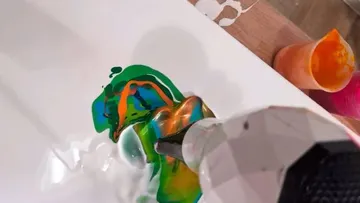 Farben werden mit einem Gerät auf die Oberfläche aufgetragen.