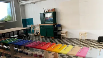 Colourful hues on tables surrounded by chairs and cupboards.