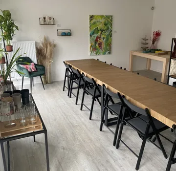 Long wooden table with black chairs in modern room.