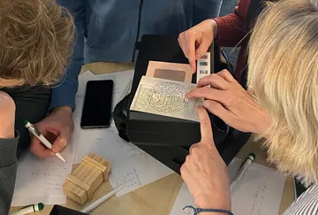 Menschen untersuchen gemeinsam ein Labyrinth auf einer Karte.