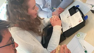 Gruppe lernt zusammen mit Anleitungen an einem Tisch.