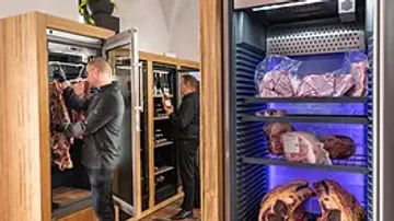 Meat is processed and stored in a modern refrigerated display cabinet.