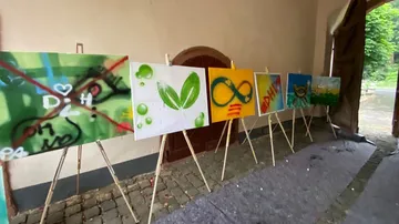 There are paintings in a hall, various colors and symbols.