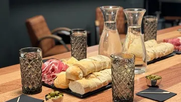 Brot, Schinken und Wasser stehen auf einem Tisch.