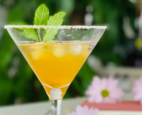 Ein Cocktail mit Minze steht vor einem grünen Hintergrund.