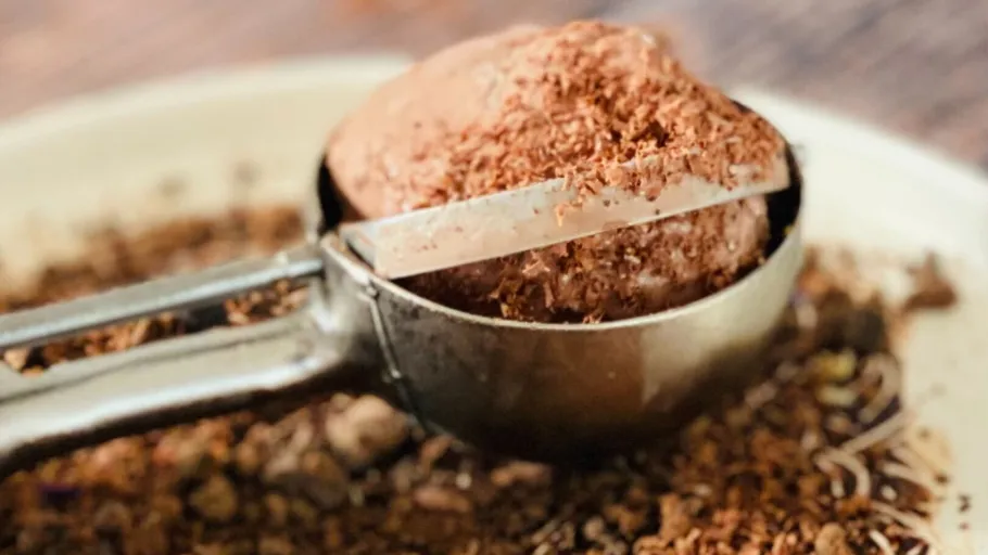 Ice cream scoop removes chocolate ice cream from minced chocolate.